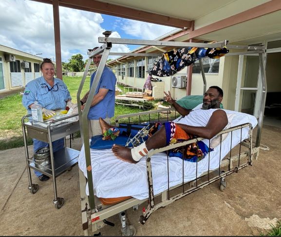 Healthcare worker with patient laying on bed